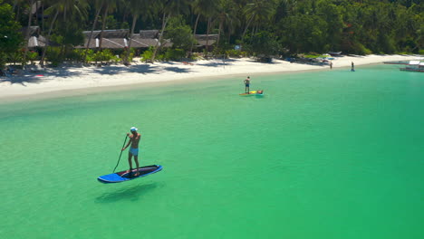 people enjoying stand-up paddleboarding in clear tropical waters