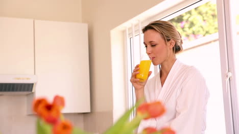 Mujer-Feliz-Bebiendo-Jugo-De-Naranja-Por-La-Mañana-