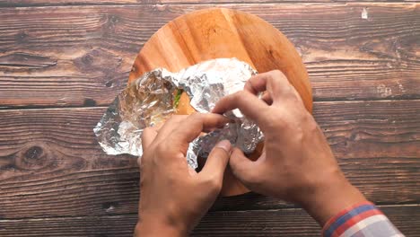 preparing a foil wrapped hamburger