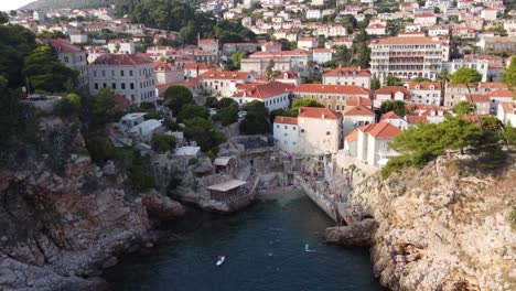 gente local nadando y relajándose en la playa rocosa de sulic en la ciudad de dubrovnik, aérea