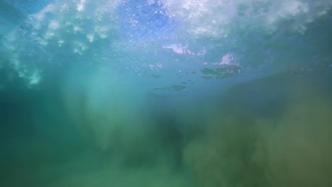 underwater pov of a wave's peak and trough in slow motion