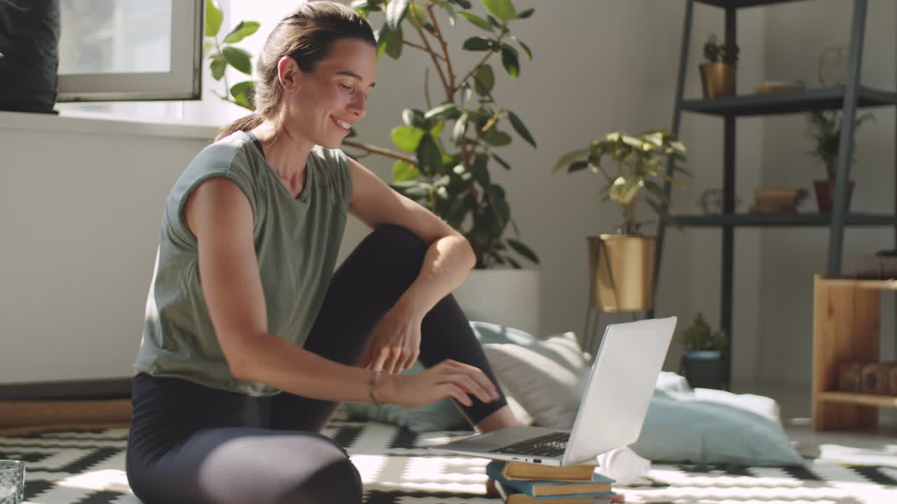 joven alegre chateando en la web llama en la computadora portátil en casa