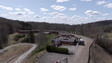 aerial drone footage dollying forward over a creepy abandoned hotel on top of a hill