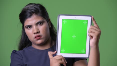 joven sobrepeso hermosa mujer de negocios india contra fondo verde