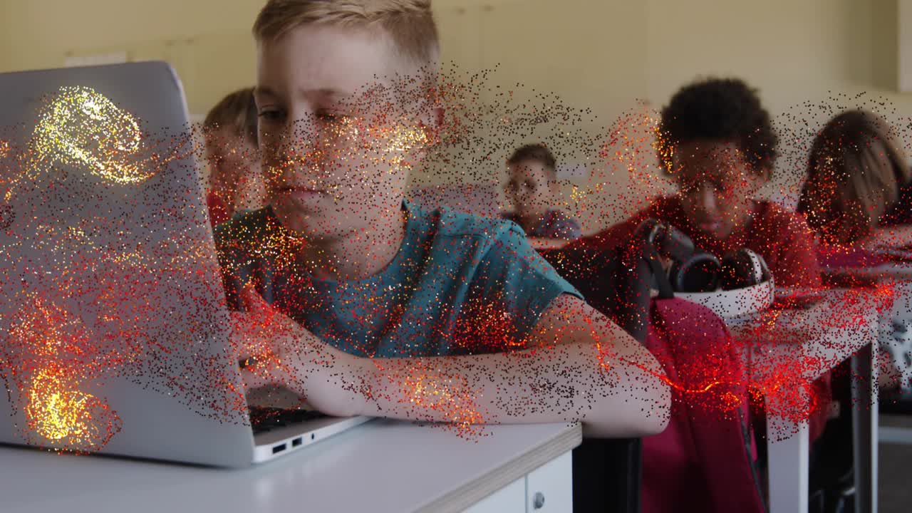 Boy typing on laptop in education class, particle sweeping in from left briefly covering laptop