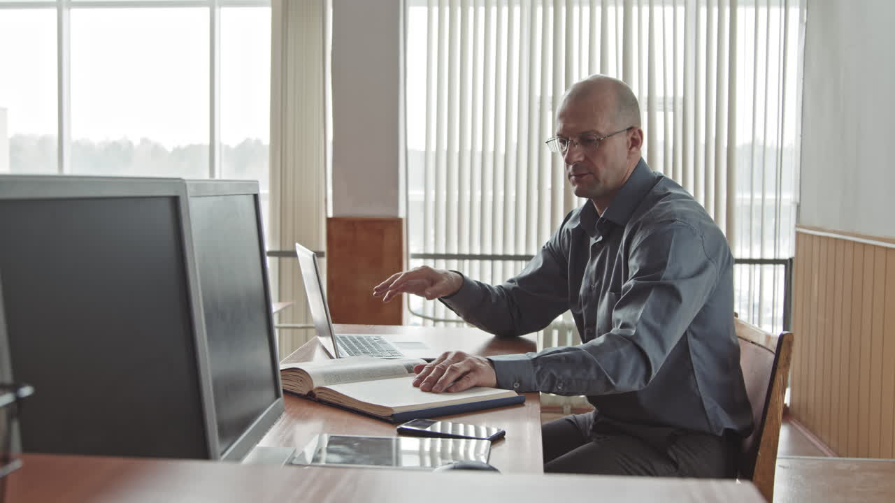 Male Teacher Having Online Lesson on Laptop in Classroom