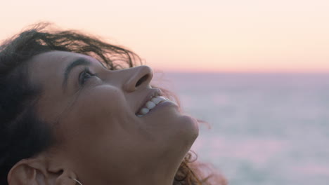 close up portrait of beautiful hispanic woman looking up exploring mindfulness contemplating spirituality with wind blowing hair enjoying peaceful seaside at sunset