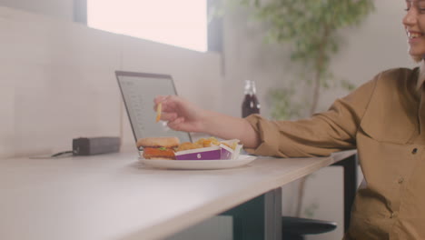 Pregnant-Woman-Talking-On-Her-Mobile-Phone-While-Sitting-At-Desk-During-Office-Lunch-Break-1