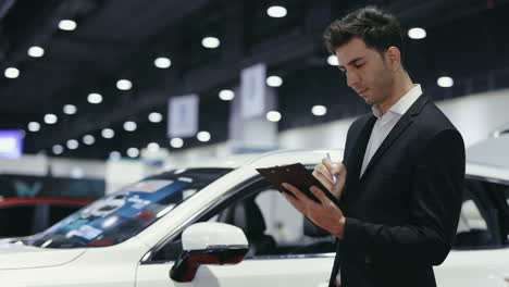 businessman checking car inventory at a showroom