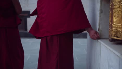 monk walking around the ancient stupa and spinning the prayer wheels in tabo monastery - buddhist temple in tabo village of spiti valley, himachal pradesh, northern india