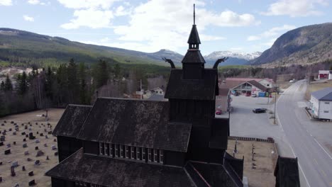 Ascending-aerial-view-in-front-of-a-stave-church-replica,-spring-in-Uvdal,-Norway