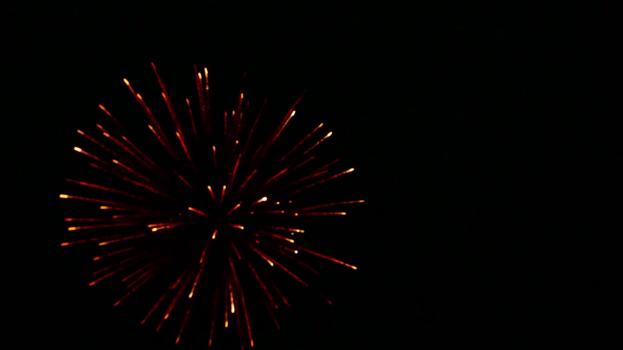Spettacolari fuochi d'artificio colorati che illuminano il cielo notturno scuro, con scintille radiose, scie luminose e scoppi drammatici che creano un'atmosfera festosa