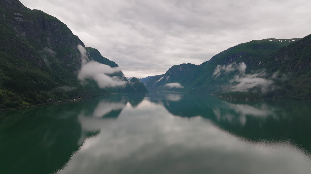 impresionante vista del agua tranquila del lago que refleja la cordillera montañosa y el cielo