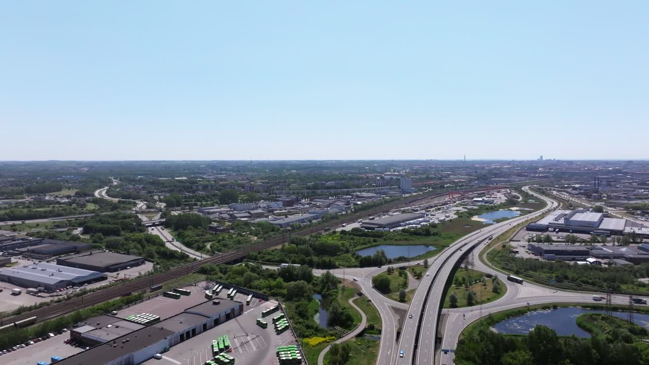Urban city Malm&ouml; with highway intersection and railway tracks, aerial backward