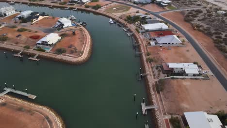 Antena-De-Drones-Que-Va-Desde-Casas-En-Un-Puerto-Hasta-La-Playa-En-Exmouth