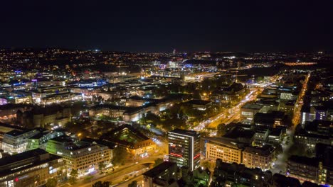 moving aerial night time lapse in 4k of downtown skyline in the city of stuttgart, germany from left to right