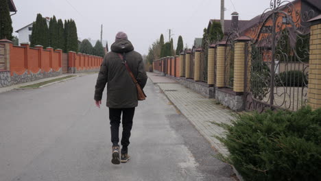 hombre caminando por una calle en una ciudad de otoño