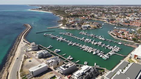 aerial drone footage of flying over mindarie marine and the pier and boats on a clear summers day