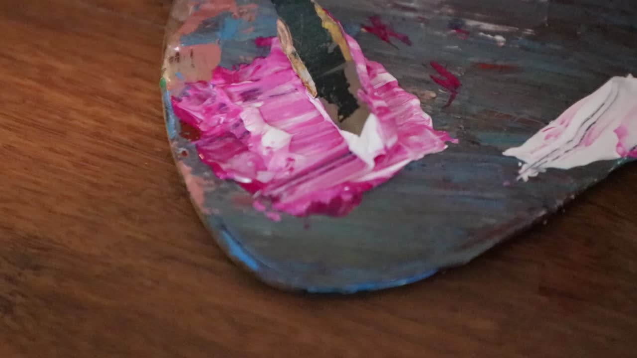 Mixing Scraper is used to mix white and pink paint. Closeup and Slow-motion.