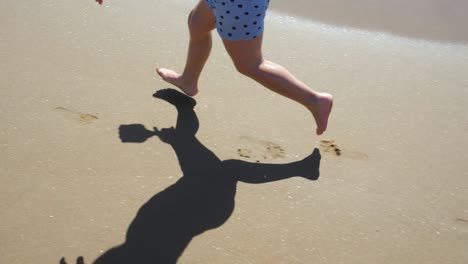 close-up of a three-year-old boy's feet running fast along the beach, shooted in slow motion