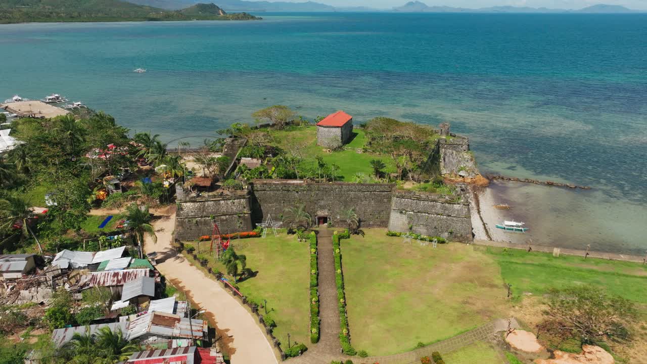 Taytay Fort Palawan'ın, berrak denizin yanındaki antik taş duvarlarını gösteren drone görüntüsü