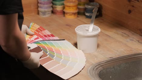 a worker applies a paint sample to a palette for color verification