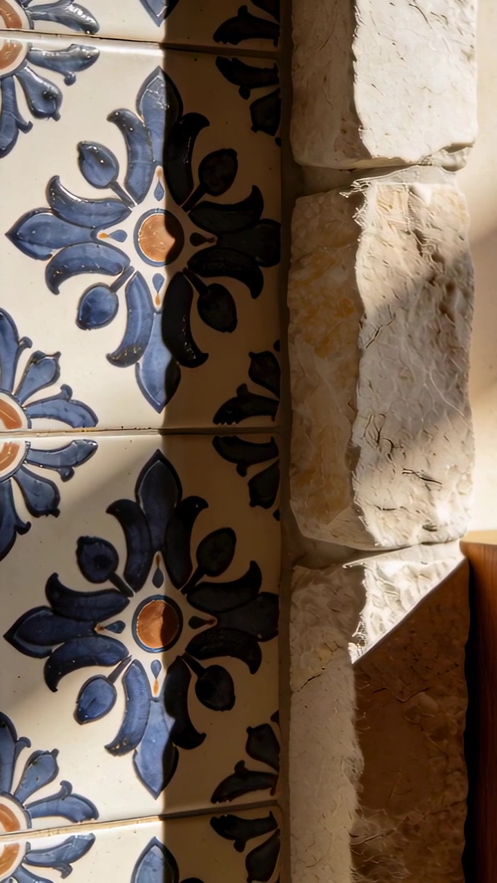 Video verticale: Sole cangiante che mostra la texture del davanzale in pietra a destra della finestra, vicino a piastrelle blu, con spazio per il testo.