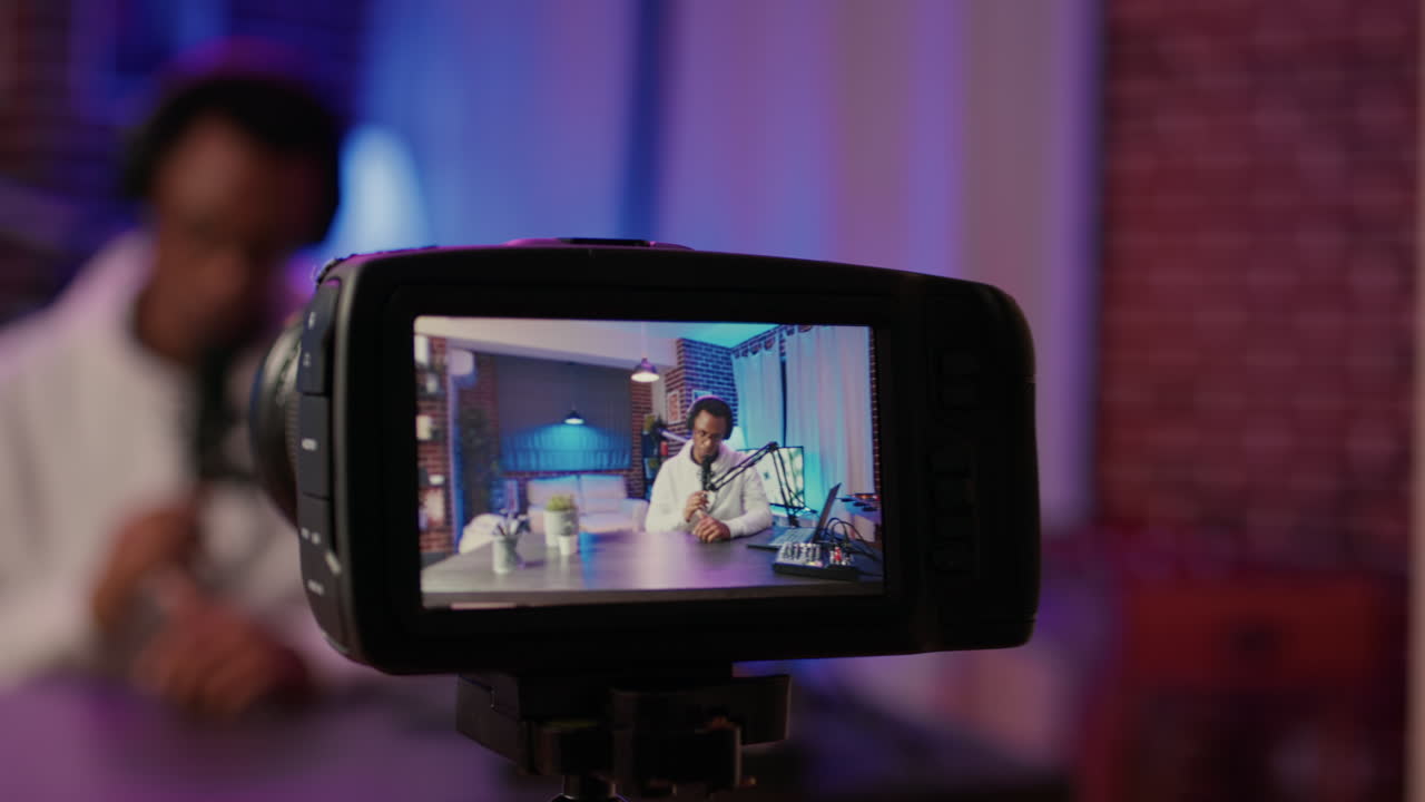 Selective focus on digital video camera screen recording african american influencer hosting podcast