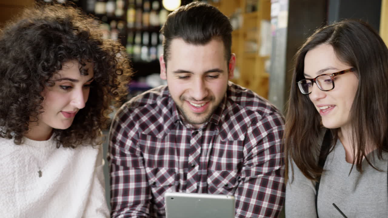parejas jóvenes compartiendo una tableta disfrutando