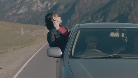 lady-with-dark-hair-leans-out-of-speeding-car-window