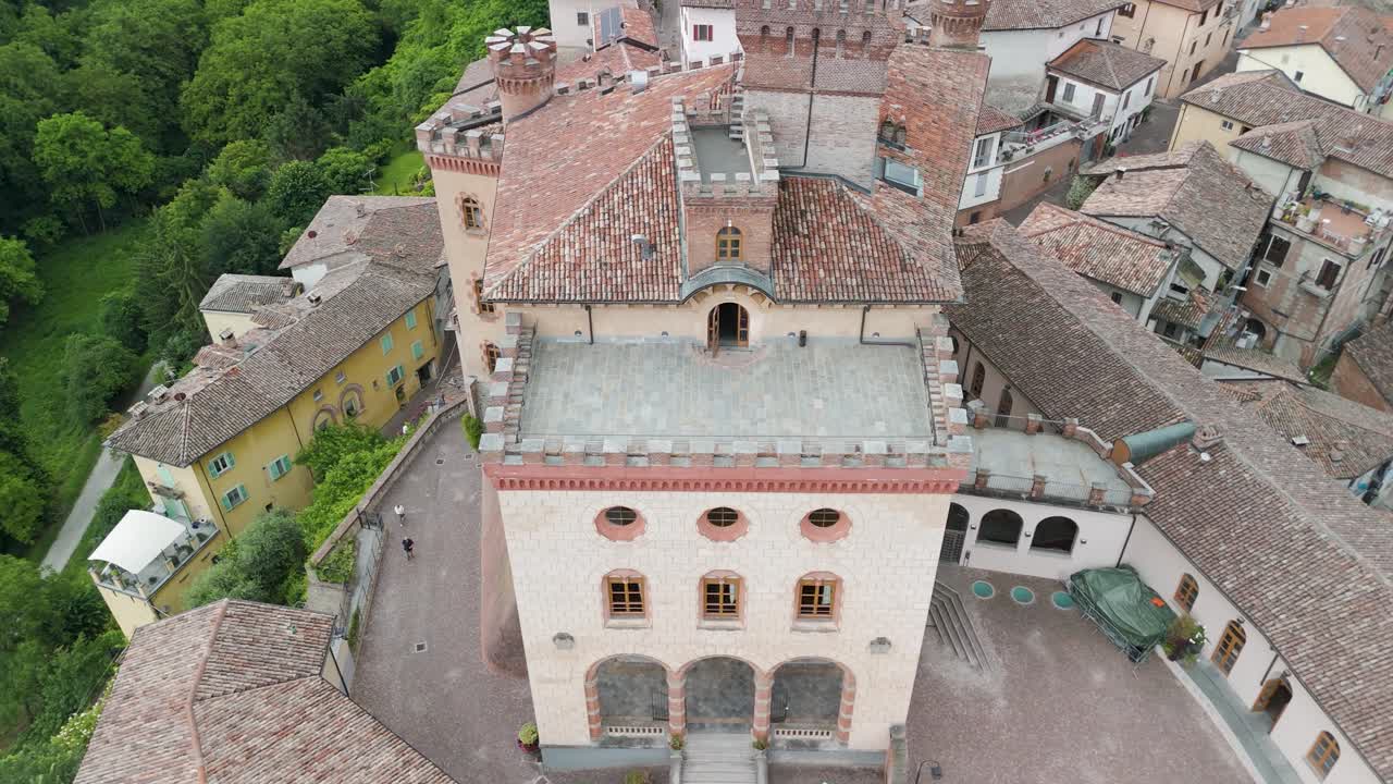 Barolo Castle in Langhe Wine Region, Cuneo, Piedmont, Italy. 4K Aerial view of the village and the vineyards, tilt up descending close to the castle.