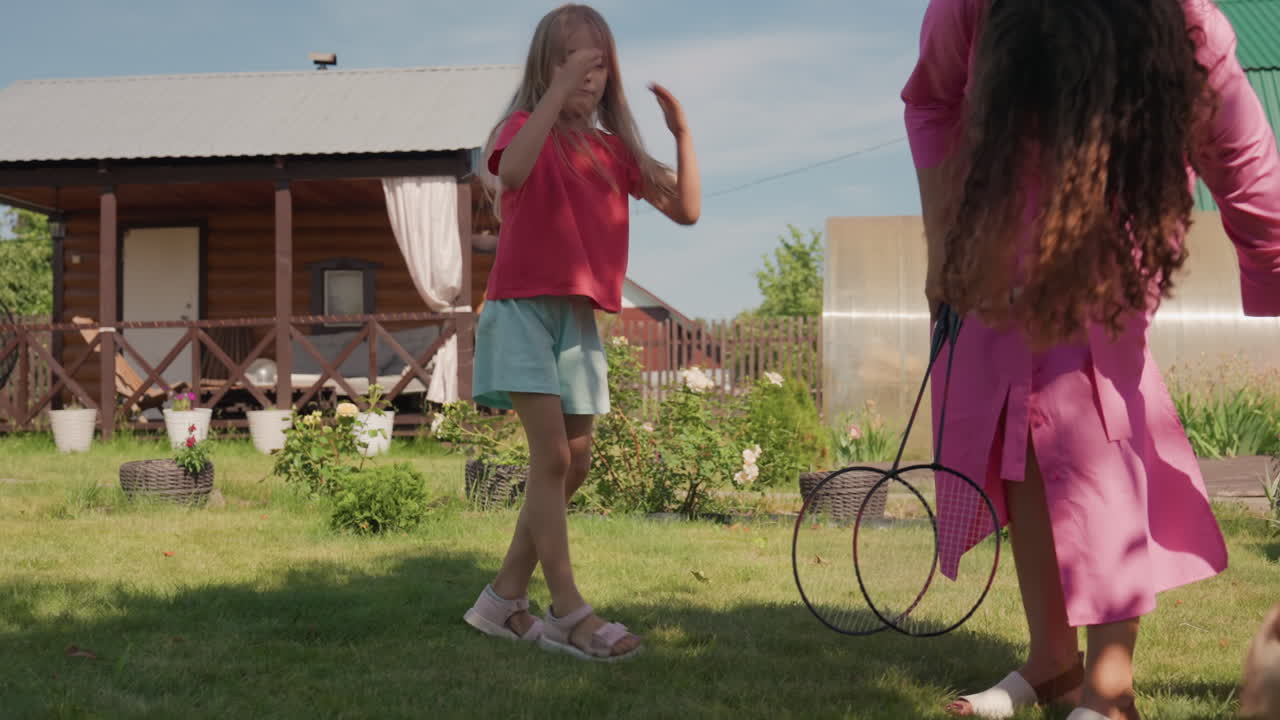 Garden Sharing Moment With Caucasian Daughter And Mother Exchanging Hoop Toy On Lawn, Lighthearted Summer Play, Gentle Gestures, Curious Child Watching Pet, Candid Family Interaction Near Wooden Porch