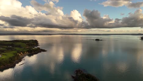 stunning view of tranquil sea waters reflecting soft golden light beneath a cloudy sunset sky. the calm surface and dramatic sky create a peaceful, contemplative scene