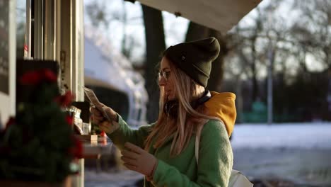 woman choosing goods in street kiosk on winter walk, think for order