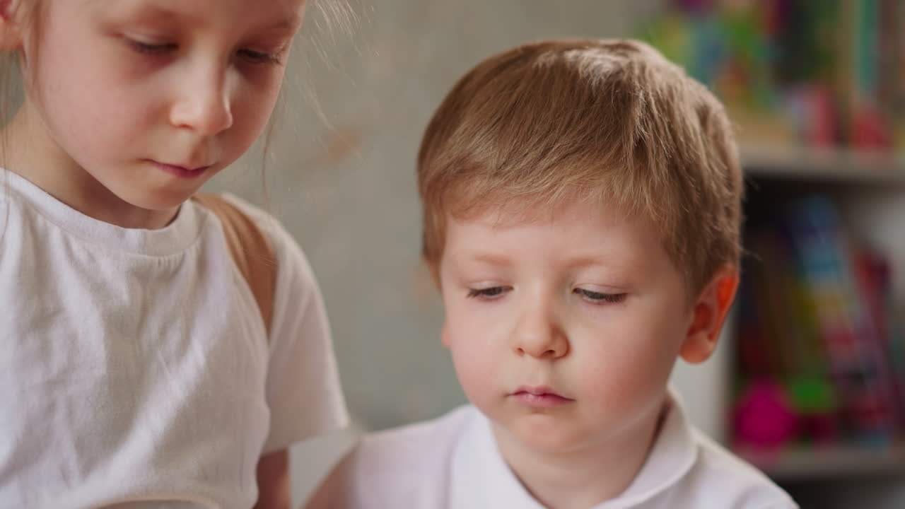 Bambini piccoli concentrati giocano a un gioco da tavolo all'asilo.