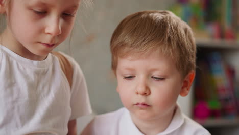 concentrated little children play board game in kindergarten