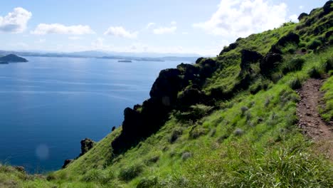 Empinadas-Laderas-Cubiertas-De-Hierba-Verde-De-Una-Isla-Tropical-Rocosa-Y-Escarpada-Con-Vistas-Al-Océano-En-El-Este-De-Nusa-Tenggara,-Indonesia