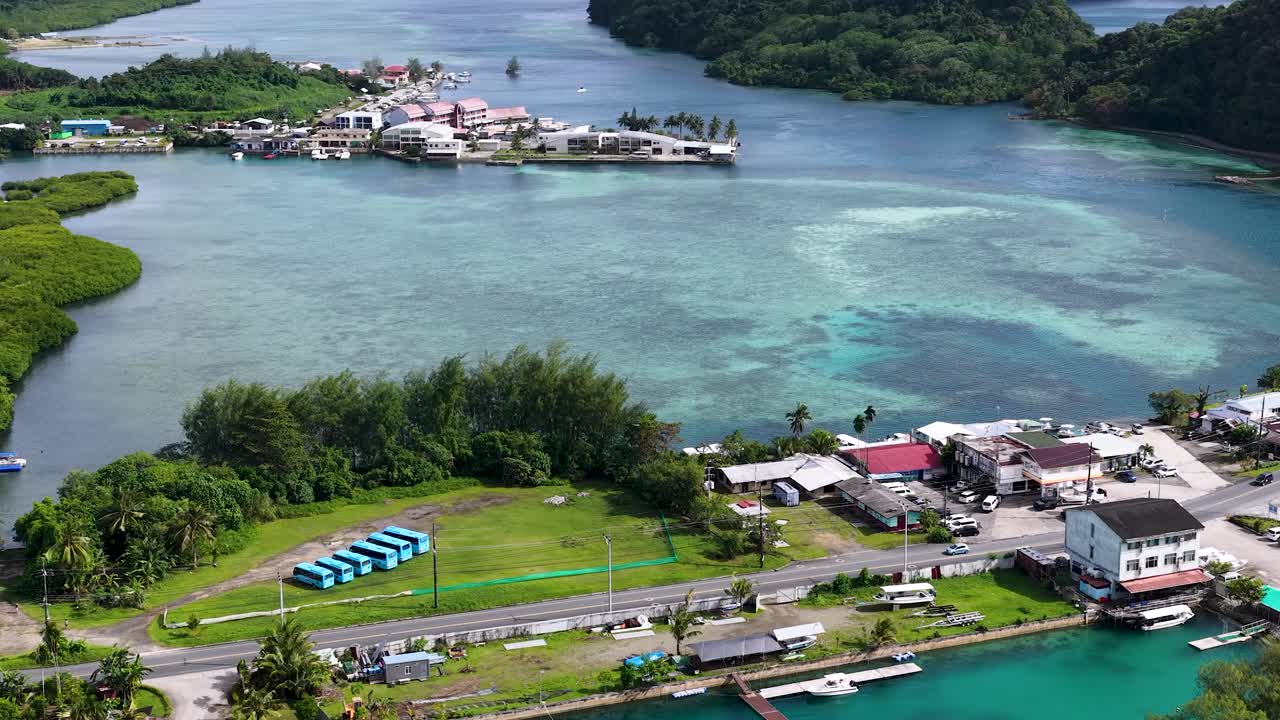 Una ripresa aerea con drone dall'alto rivela una città costiera tropicale accanto all'acqua turchese dell'oceano a Palau.