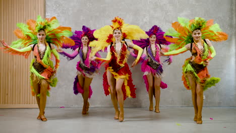 flve cabaret dancer performing a samba dance in colorful feather gowns