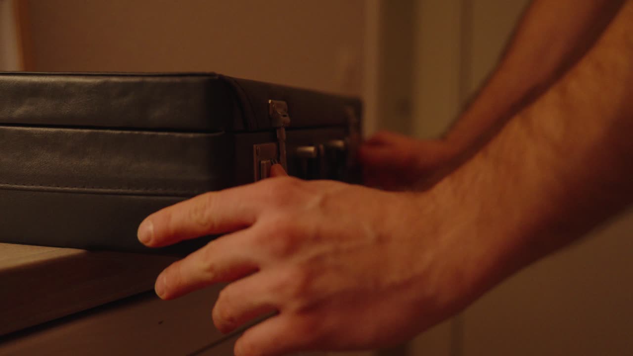 classic briefcase: a man opens a briefcase close up