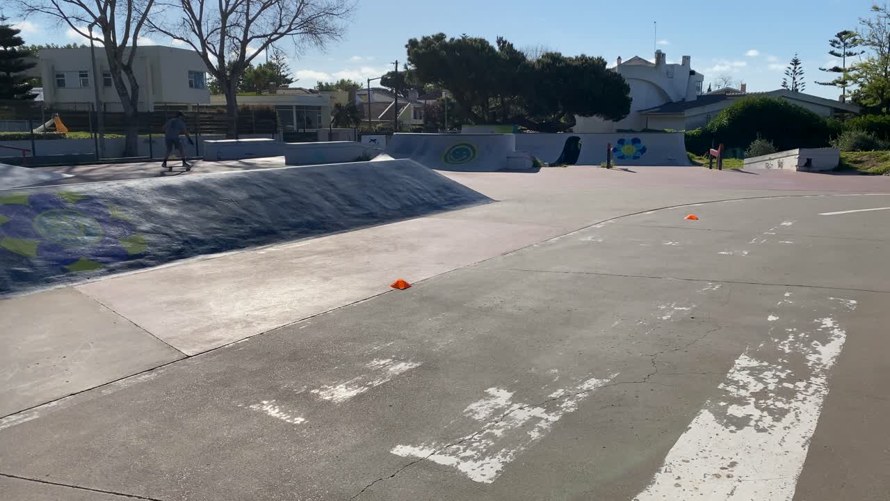 스케이트보드를 타고 있는 젊은 남자가 시원한 스타일과 행복한 감정으로 활발한 야외 생활 방식을 즐기고 있습니다.