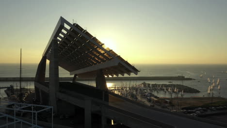 Sonne,-Die-Hinter-Barcelona-Auftaucht,-Solarpaneelstruktur,-Aufsteigende-Luftansicht,-Parc-Del-Forum-Marina