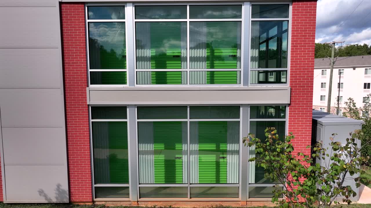 Extra Space Storage Building with modern architecture during sunny day in american town. Rising drone wide shot.