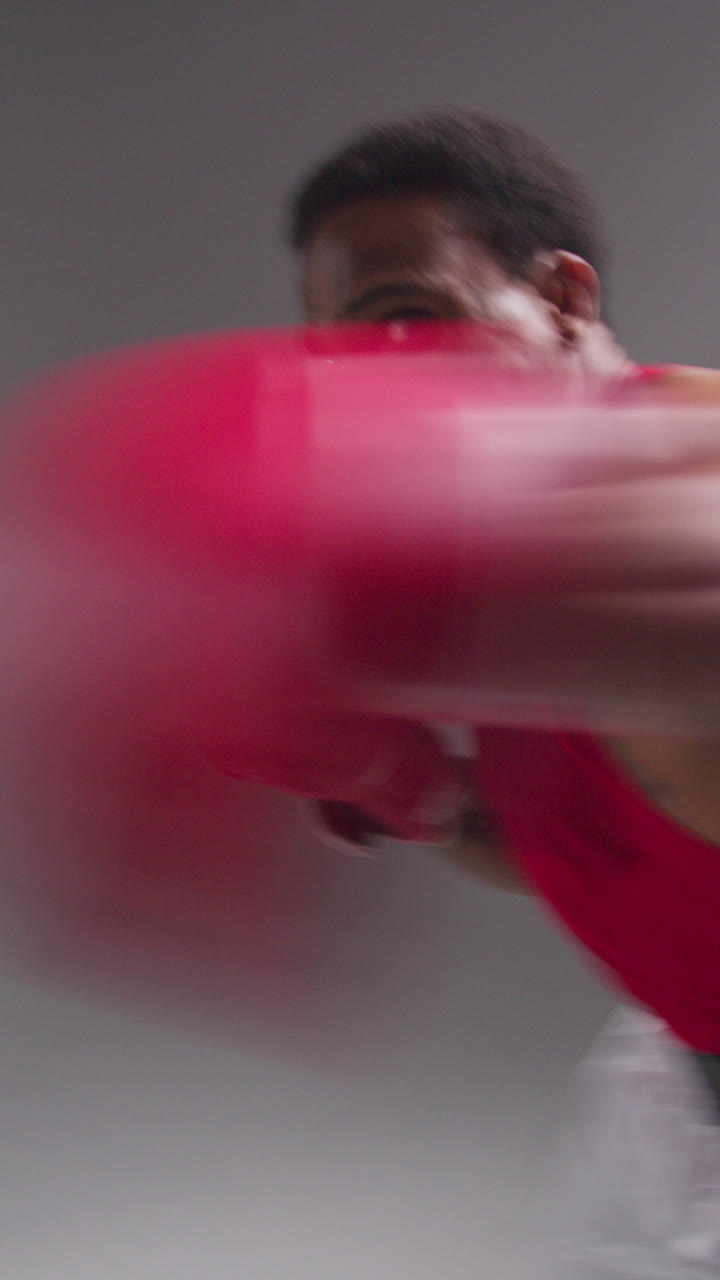 Vertical Video Real Time Studio POV Shot Of Male Boxer Wearing Boxing Gloves In Boxing Match Punching Towards Camera