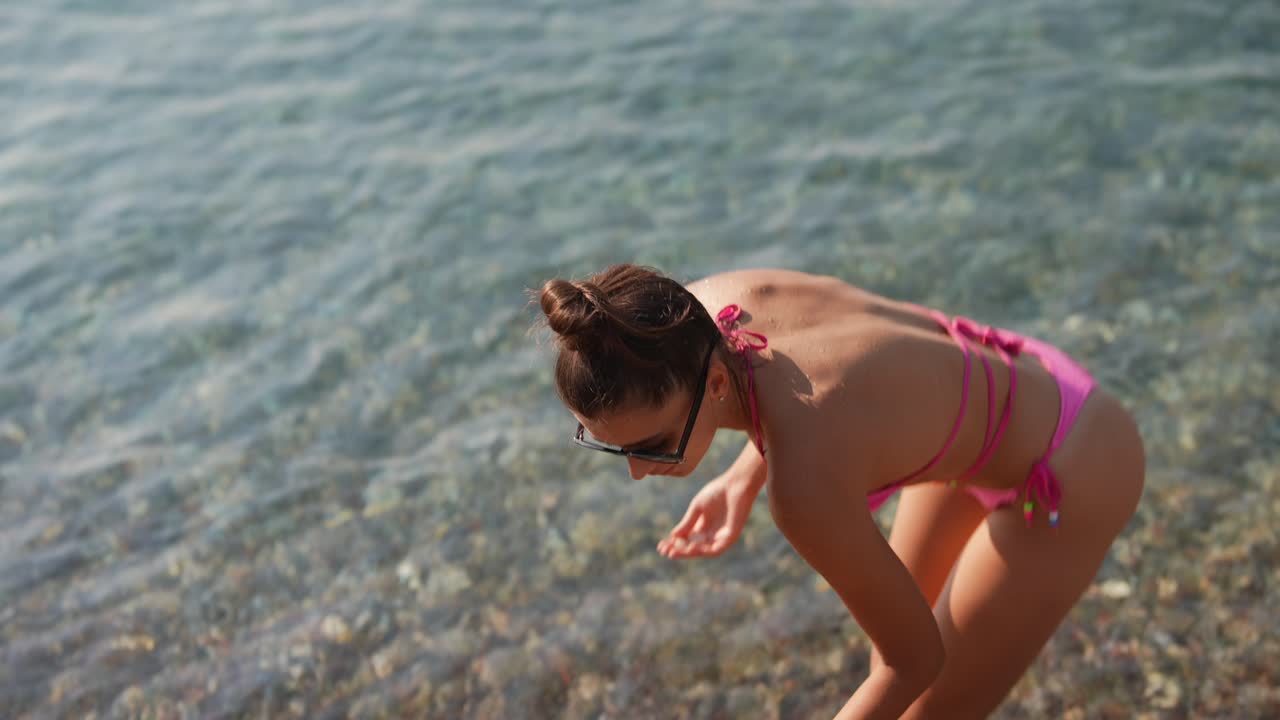 Donna in bikini rosa in spiaggia
