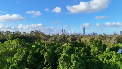 aerial footage captures lush greenery, a serene lake, and the gold coast skyline under a bright blue sky