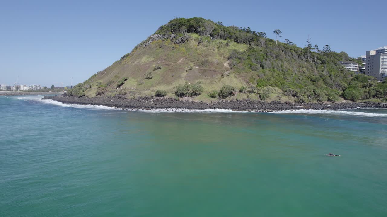 surfistas en el mar azul en verano con vista a las cabezas de burleigh en qld, australia