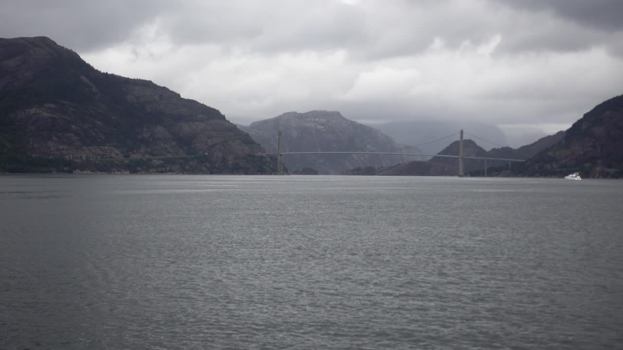 흐리고 변덕스러운 날씨와 배경에 흰색 보트가 있는 페리에서 촬영된 노르웨이 다리