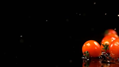 tomates rodando en el agua contra un fondo negro 4k