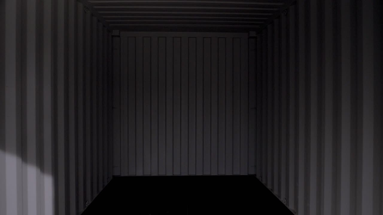 la toma de dolly hacia atrás revela la longitud total de un contenedor de envío vacío